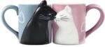 A pair of BigNoseDeer ceramic mugs, one blue and one pink, designed with cat faces that appear to kiss when placed together.