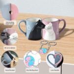 A pair of BigNoseDeer ceramic mugs, one blue and one pink, designed with cat faces that appear to kiss when placed together.