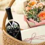 HEXMOZ Mr & Mrs 2026 heart-shaped glass ornament in a navy blue gift box with an ivory ribbon, hanging.