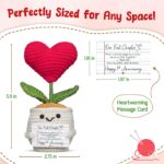 A small, red crochet doll with a flower head and a heart-shaped body, resting on a flat surface.