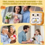 Close-up of a small, square, light brown crochet toast plush with embroidered eyes and a red heart, holding a white banner th