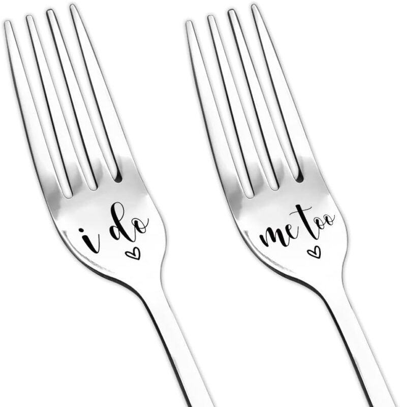 Two silver stainless steel dinner forks, one engraved 'I do' and the other 'me too', arranged on a clean background.